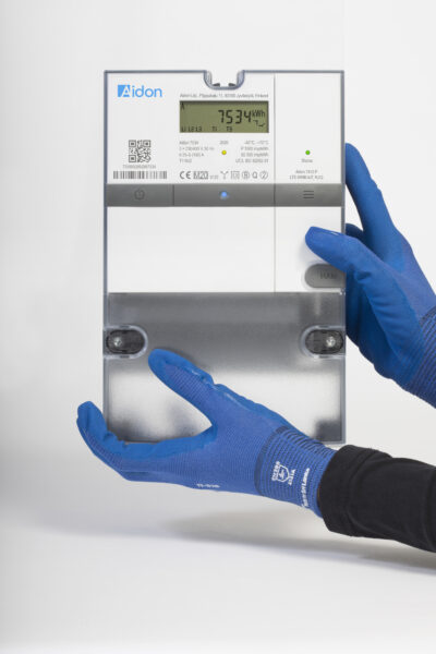 Hands with blue gloves hold up an electric meter.