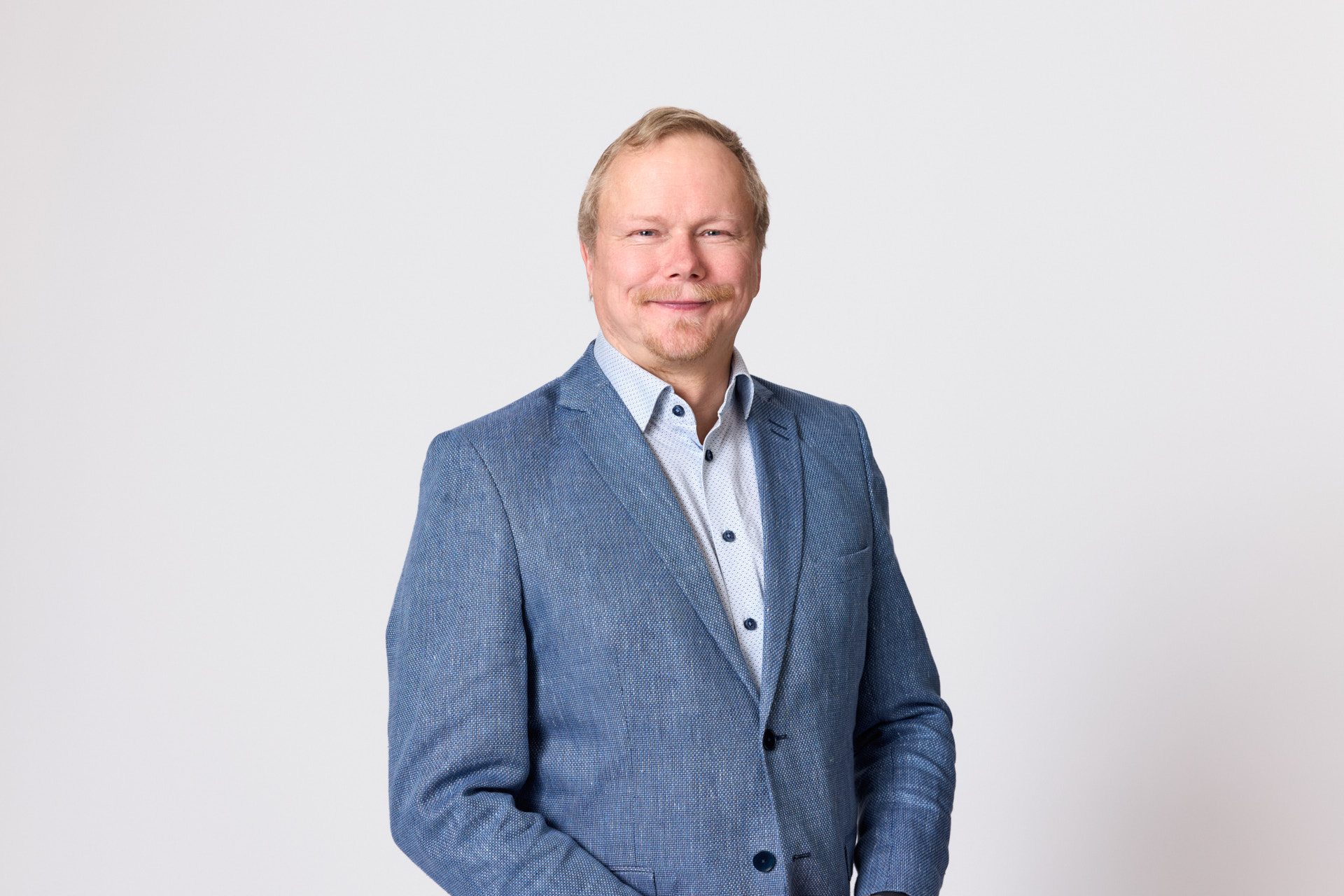 A blonde man in a suit posing for the camera.