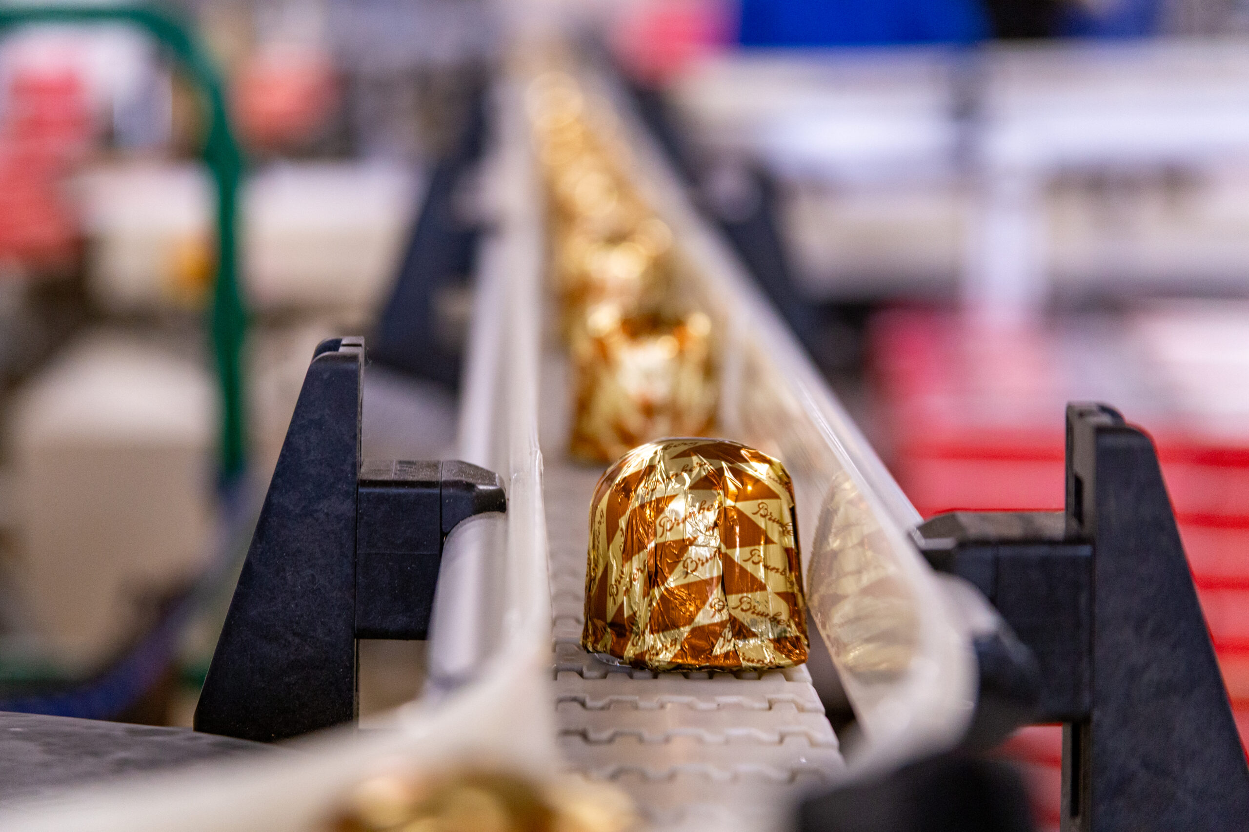 Wrapped chocolate kisses coming down a factory line.